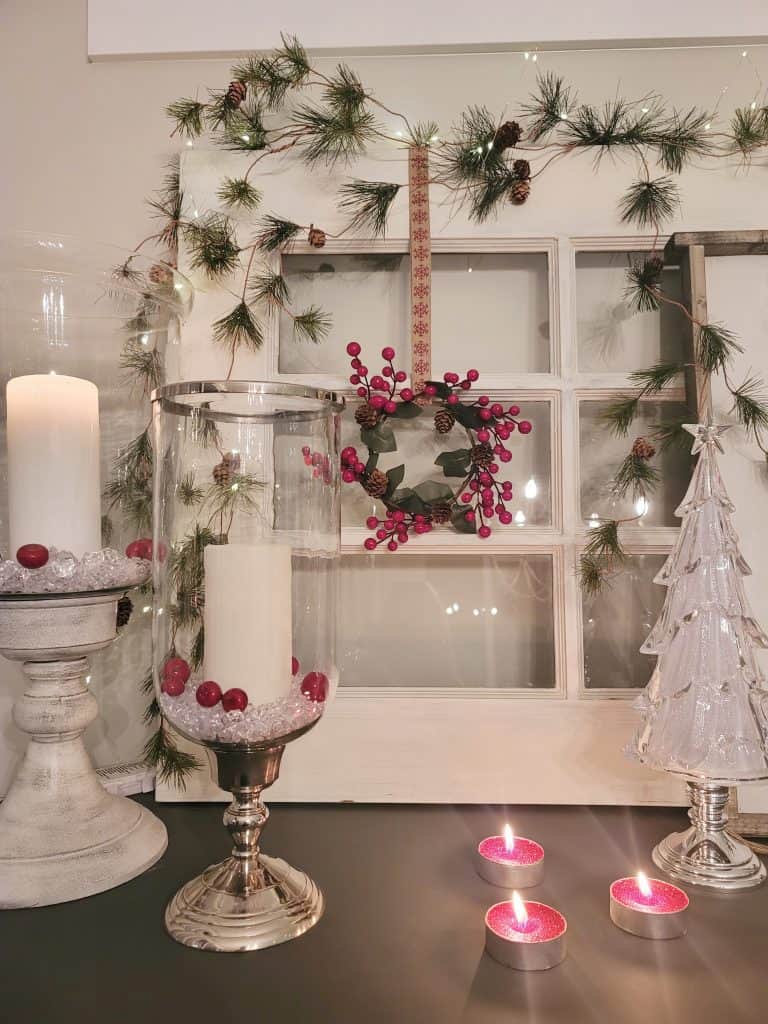 Vintage french door on it's side with red berry wreath and candles