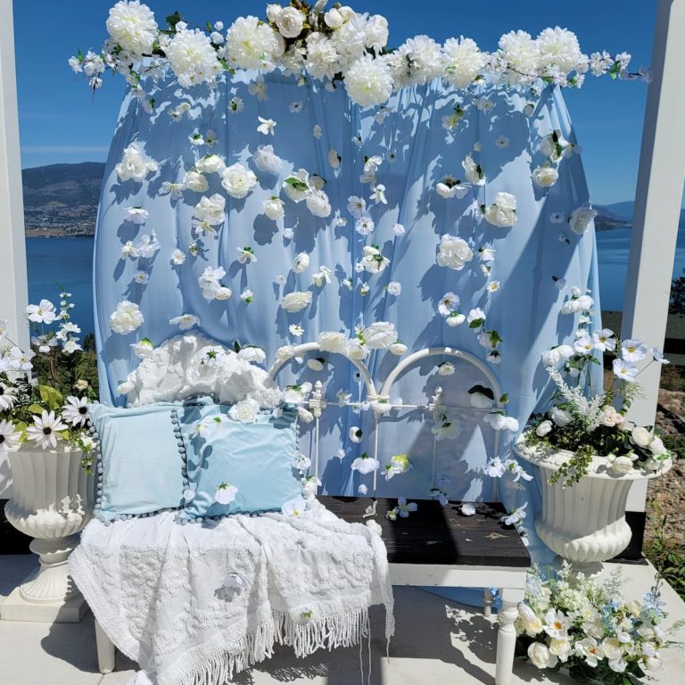 Blue and white flower wall behind bench with urns and flowers